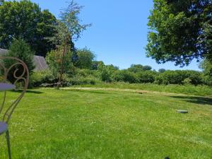 a yard with a bench in the grass at La petite Salamandre bleue in La Croisille-sur-Briance