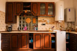 a kitchen with wooden cabinets and a white refrigerator at La Poalele Cerului in Fundata
