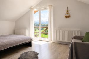 a bedroom with a bed and a large window at La Poalele Cerului in Fundata