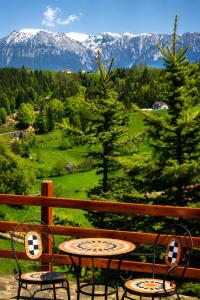 two chairs and a table on a balcony with mountains at La Poalele Cerului in Fundata +9 photos