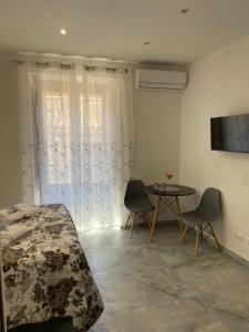 a bedroom with a bed and a table with chairs at L'Approdo di Re Ruggero in Cefalù