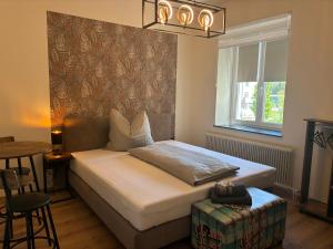 a bedroom with a bed and a table and a window at Pension Grum in Arnoldstein