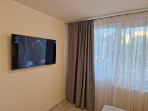 a room with a tv and a window with curtains at Iris central Mangalia 2 bedroom apartment in Mangalia