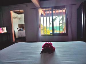 a bedroom with a bed with a flower arrangement on it at Maisonnette en bord de mer in Antsiranana +9 photos