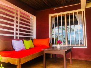 a red couch sitting in a room with a window at Maisonnette en bord de mer in Antsiranana