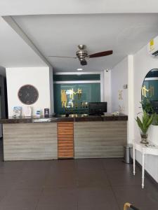 a reception desk with a clock in a room at Hotel LHM in Montería