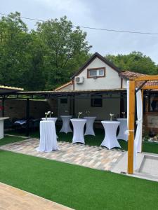 a group of tables and chairs on a patio at Vikend house Cvrcak in Slankamenački Vinogradi