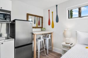 a kitchen with a refrigerator and a table with stools at Assateague Inn 100-2R in Chincoteague