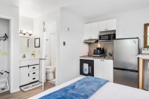 a small kitchen with a refrigerator and a sink at Assateague Inn 100-2R in Chincoteague