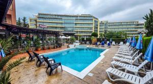 a swimming pool with chairs and a large building at Friends Family Hotel in Sunny Beach