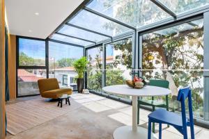 a conservatory with a table and chairs and windows at The 21 by Homie in Ribeira Brava
