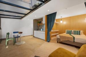 a bedroom with a bed and a table and a kitchen at The 21 by Homie in Ribeira Brava +52 photos