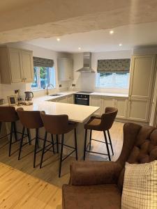 a kitchen and living room with a table and chairs at Hughie Toms Cottage in Greencastle