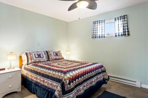 a bedroom with a bed and a ceiling fan at Assateague Inn 105-S in Deep Hole +16 photos