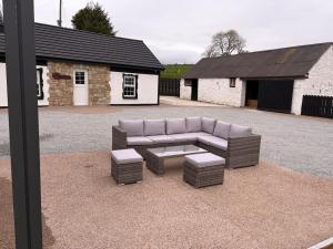 a couch and a coffee table in front of a building at Hughie Toms Cottage in Greencastle