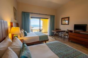 a hotel room with two beds and a balcony at Las Villas Hotel & Golf By Estrella del Mar in Mazatlán +32 photos