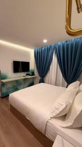 a bedroom with a large bed with blue curtains at THE SWAN loft in Sibu