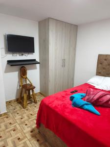 a bedroom with a red bed with a tv on the wall at apartamento vacacional red 1 in Salento