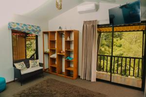 a living room with a tv and a balcony at Hotel Ecopaisajes- Lake-Premier-Resort in Santa Rita