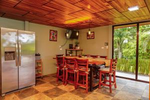 a kitchen with a wooden ceiling and a table and chairs at Hotel Ecopaisajes- Lake-Premier-Resort in Santa Rita