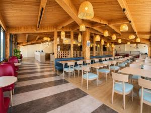 a restaurant with wooden ceilings and tables and chairs at Ramada by Wyndham 1000 Islands Gananoque in Gananoque