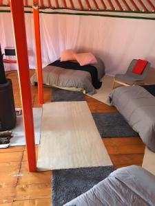 a room with several pillows and blankets in a tent at Yourte Volcans Puy de Dome in Montfermy