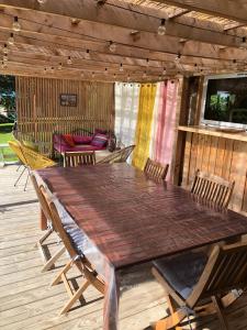 a wooden table and chairs on a wooden deck at Yourte Volcans Puy de Dome in Montfermy