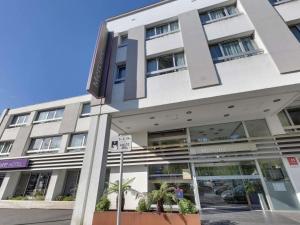 a large white building with a sign in front of it at Mercure Lorient Centre in Lorient