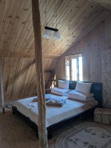 a bed in a room with a wooden ceiling at Яблунева садиба in Demidovka +24 photos