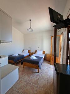 a living room with two beds and a flat screen tv at AVRA Apartments & Studios in Frý