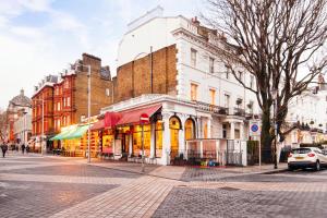 un bâtiment dans une rue de la ville avec des voitures garées dans l'établissement Elicia's South Kensington Apartment, à Londres