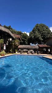 a swimming pool with blue water in a resort at Pousada Saudosa Maloca in Arraial d'Ajuda