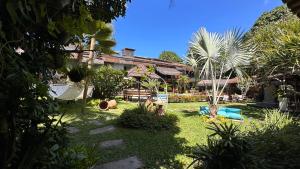 a resort with a yard with palm trees at Pousada Saudosa Maloca in Arraial d'Ajuda