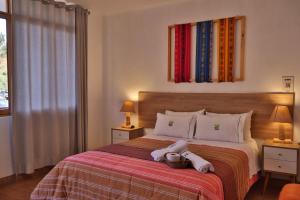 a bedroom with a bed with two towels on it at Tambo Lodge Canta in Canta