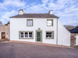 a white house with a green door on a street at 2 Bed in Penrith oc-87349 in Penrith