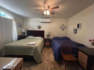 a bedroom with two beds and a ceiling fan at Casa Villafontana in Mexicali