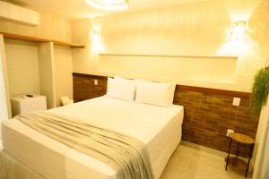a bedroom with a bed with white sheets and pillows at Desfrute Pousada e Experiencia in Arraial d'Ajuda