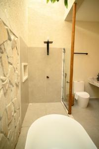 a bathroom with a toilet and a cross on the wall at Desfrute Pousada e Experiencia in Arraial d'Ajuda