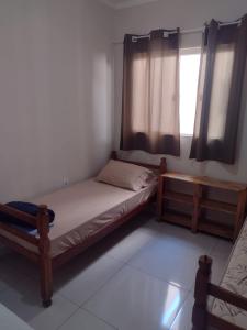 a small bedroom with a bed and a window at Hospedaria São Francisco in Cachoeira Paulista