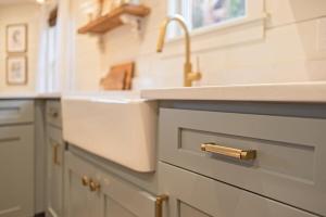 a kitchen with white cabinets and a sink andaucet at Kildahl House - Boutique Farmhouse Suite #1 in West Dundee