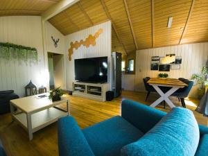 a living room with a blue couch and a tv at Ferienhaus Bambi in Haren