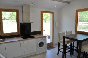 a kitchen with a washing machine and a table at Gîte dans maison Quercynoise in Vaylats