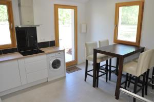 a kitchen with a table and a washing machine at Gîte dans maison Quercynoise in Vaylats +32 photos