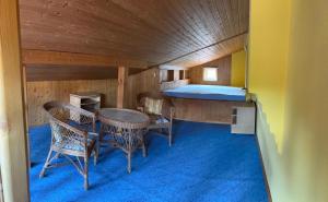 a small room with a bed and a table and chairs at Familija in Straupitz