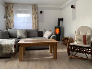 a living room with a couch and a table and a fireplace at Ferienwohnung Sprjewja in Straupitz