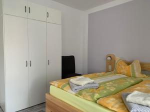 a bedroom with a bed and white cabinets at Ferienwohnung Sprjewja in Straupitz