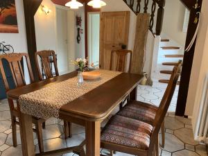 a dining room with a wooden table and chairs at Ferienwohnung Sprjewja in Straupitz
