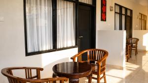 a table and chairs in a room with windows at Cahaya Adrian Hotel in Labuan Bajo +27 photos