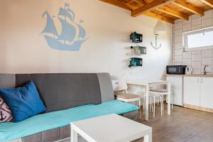 a living room with a couch and a table at Domki Anchor - Rodzinne Domki - Cisza i Spokój in Lubiatowo