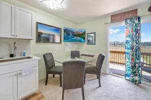a kitchen with a table and chairs and a balcony at Assateague Inn 206-S in Chincoteague